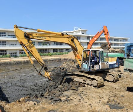 Power shovels remove top soil
