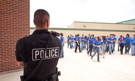 Click to enlarge male police officers supervise and keep an eye on students in South Texas high school