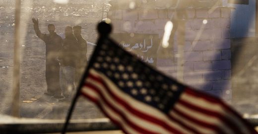 Click to enlarge Iraqis wave as the last U.S. convoy heads
