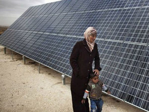 Palestinian mother & child @ solar panel