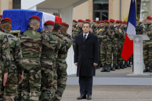 French President Nicolas Sarkozy stands by soldiers