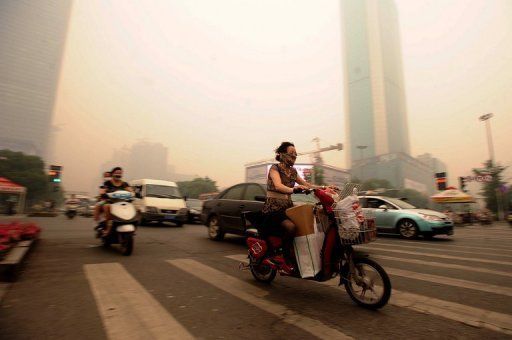 Click to enlarge Chinese motorists in Wuhan wear masks