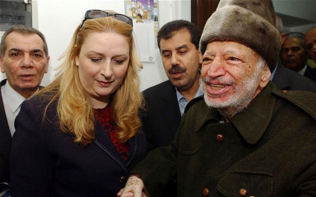 Assisted by his wife Suha (L) and two aides, Palestinian President Yasser Arafat  