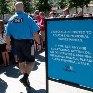 Click to enlarge guard makes sure visitors stay off the plaques at the memorial