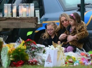 Click to enlarge Parishioners pay their respects to the victims