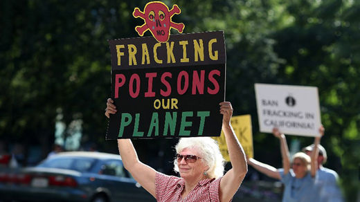 Click to enlarge Protestors hold signs against fracking