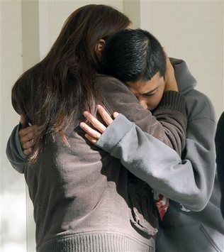 Youth hugs mother, weeping