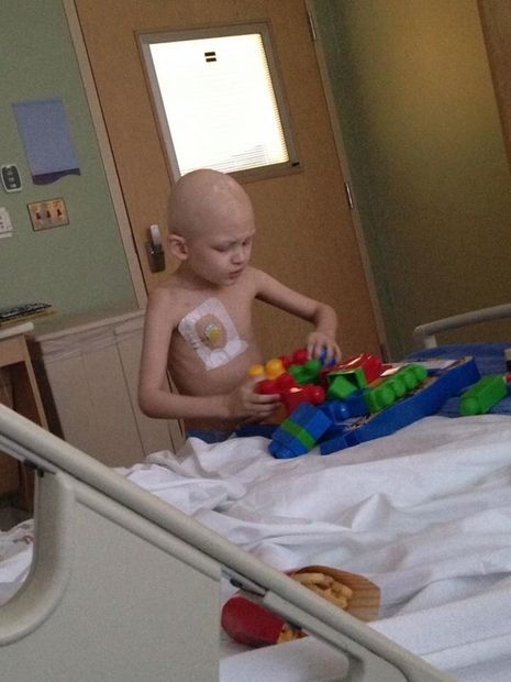 boy with cancer plays with toys