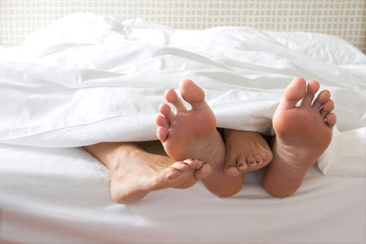 couples feet in bed
