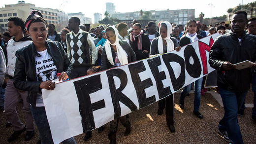 African migrants hold a sign during a protest