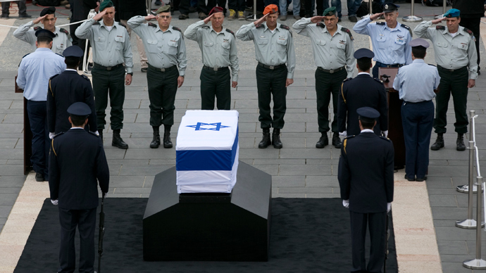 Click to enlarge Israeli army officers salute in front of the flag draped coffin