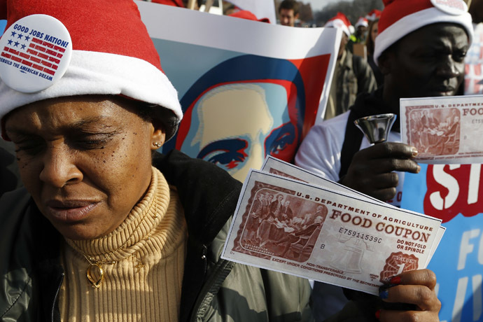 Protesters hold replicas of food stamps during a rally