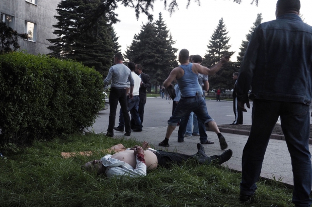 Youri Nikolenko throws a stone at the gunmen.