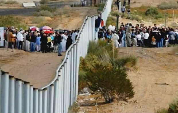 Click to enlarge border fence and immigrants