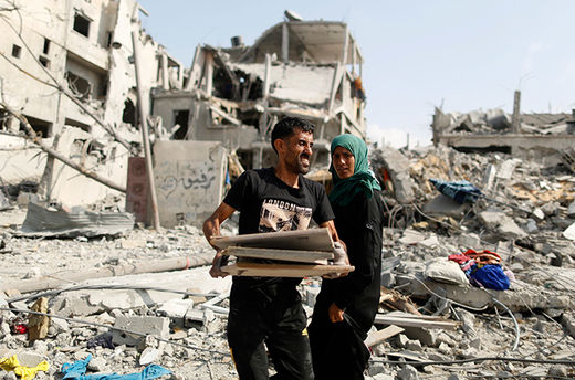 Click to enlarge Palestinian man carries his belongings